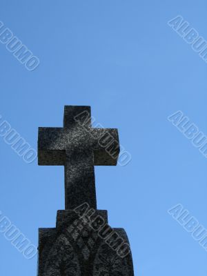 a stone cross and blue clear sky