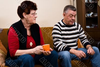 Senior couple drinking cofee in the livingroom