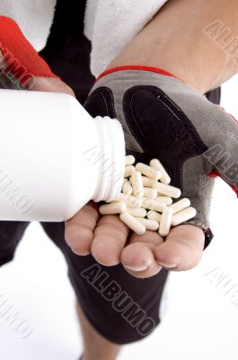 man taking capsules on hand