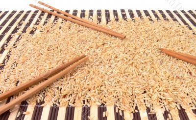 Rice and chopsticks on bamboo carpet