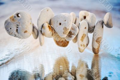Stones are reflected in a wave