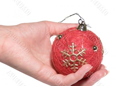 The female hand holds a Christmas ornament