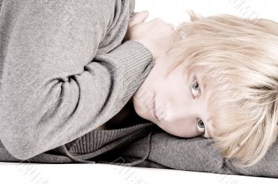 Sad looking beautiful girl lying on the floor looking at you
