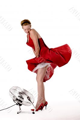 Funny girl in red gala dress playing with a ventilator