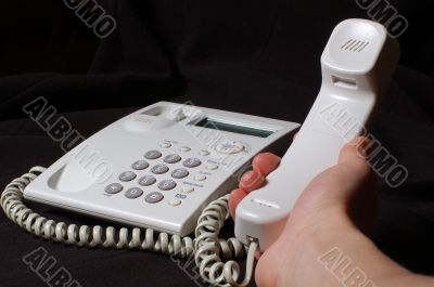 White business telephone on hand