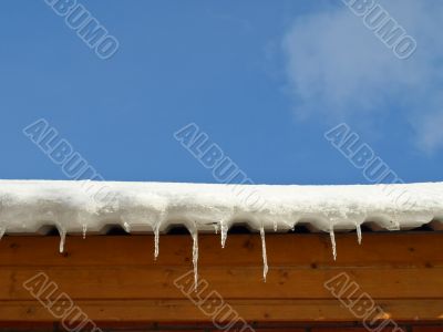 Snow with icicles on the roof
