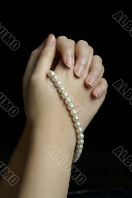 Hands in prayer with pearls