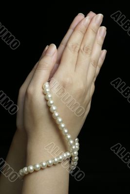Hands in prayer with pearls