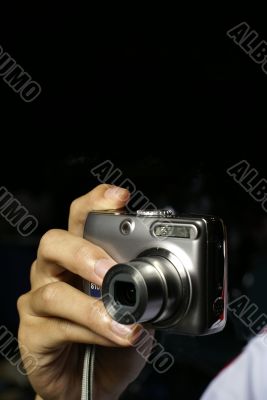 Hand holding shiny metal camera