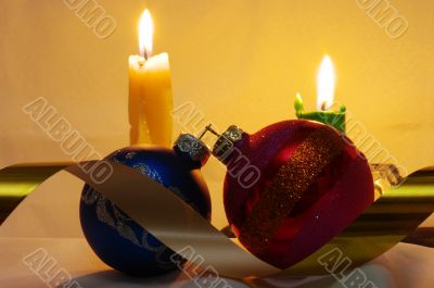 The burning candles, balls and gold ribbons it are Christmas