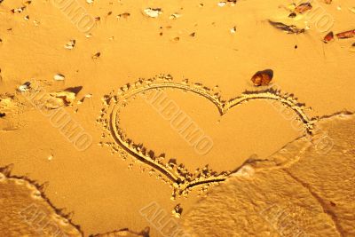 heart written on the sand on the beach of sea