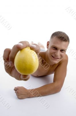 smiling muscular man showing orange