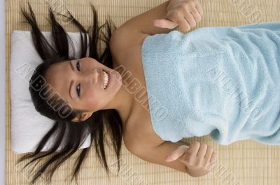 laying young woman showing thumb up