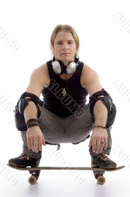 smart guy with headphones sitting on skateboard