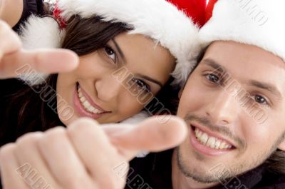 young couple wearing christmas hat and looking