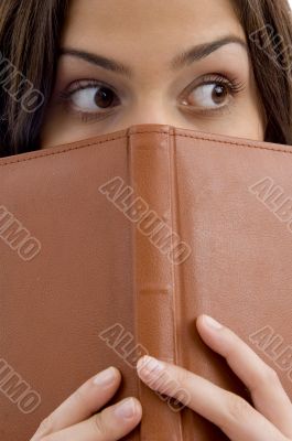 student peeping from book