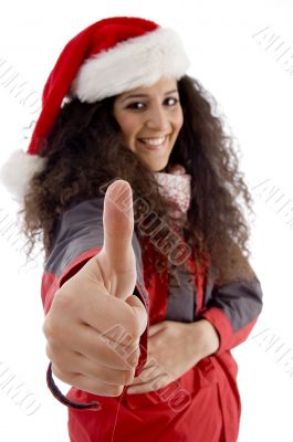 young woman with christmas hat showing thumb up