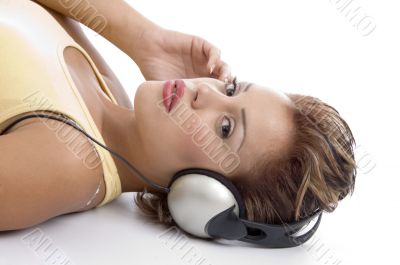 laying woman with headphone looking at you