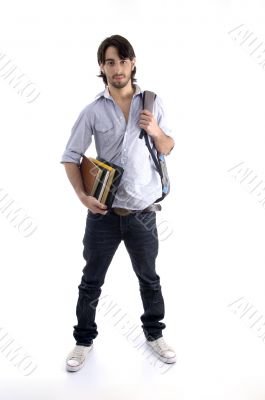 student standing with books and bag