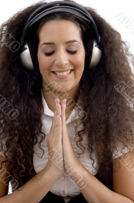 young woman listening to music and praying