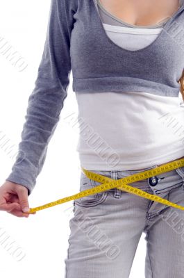 female measuring her waist with tape