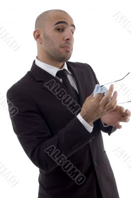 young corporate man wiping off his eyeglasses