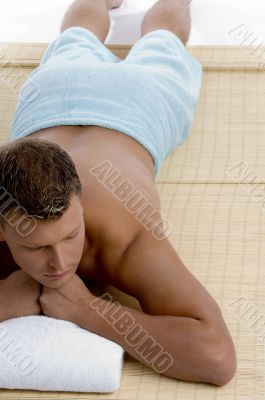 male lying on mat ready to take spa treatment