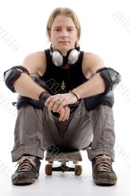 handsome american male sitting on skateboard