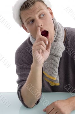 male with christmas hat putting finger in his nose
