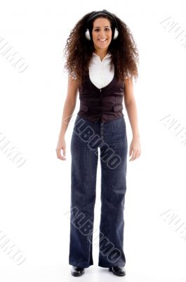 standing female listening music on headphone