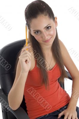 teenager girl holding pencil and looking at camera