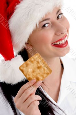 woman with christmas hat and holding biscuit