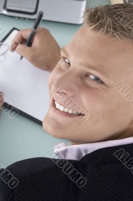 back pose of smiling man with pen and writing