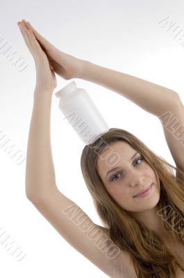 pretty female balancing plastic bottle on head