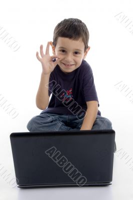 cute young boy with laptop showing okay