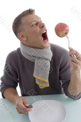 man holding apple with fork