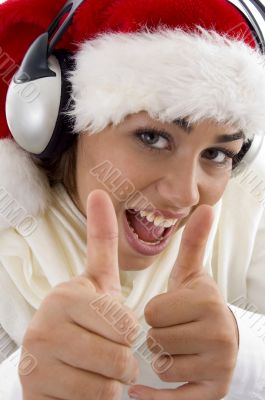 woman wearing christmas hat and showing thumbs up