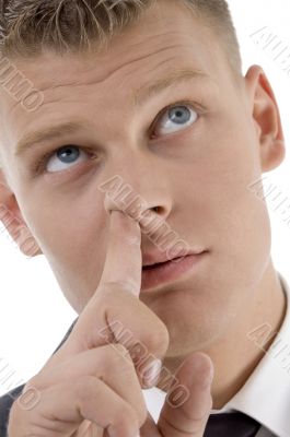 man picking his nose and looking upward