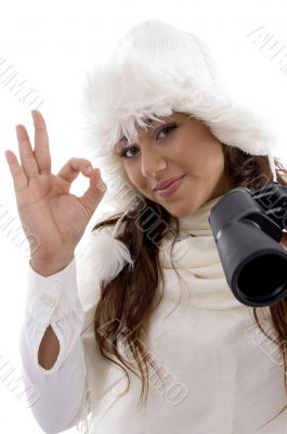 woman holding binocular and showing okay