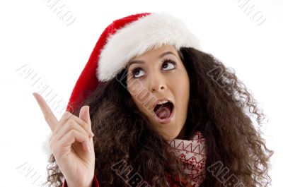 young woman with christmas hat pointing aside