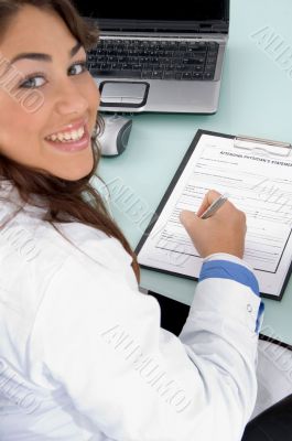 smiling doctor holding pen and looking at camera