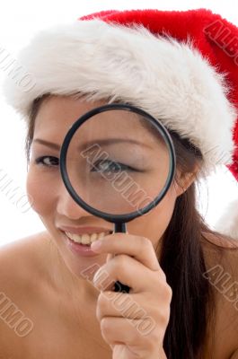 woman with christmas hat looking through magnifier