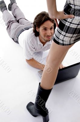 young guy lying with laptop and looking at girl