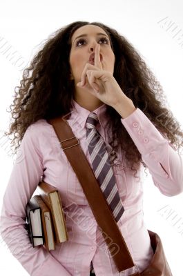 pretty young student holding books shushing