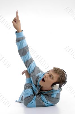 laying young man with headphone indicating upward