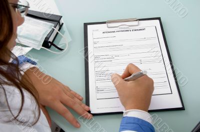 back pose of doctor writing on notepad