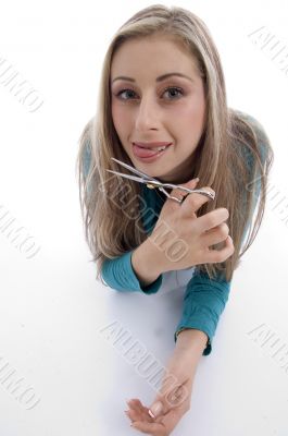 laying woman holding scissor