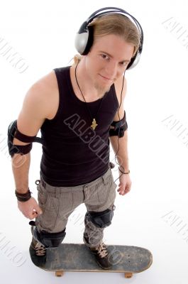 young caucasian guy standing on skateboard