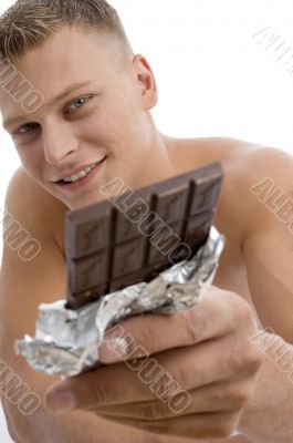 smiling muscular guy showing chocolate