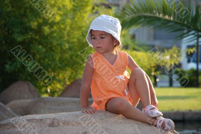 The little girl on a stone